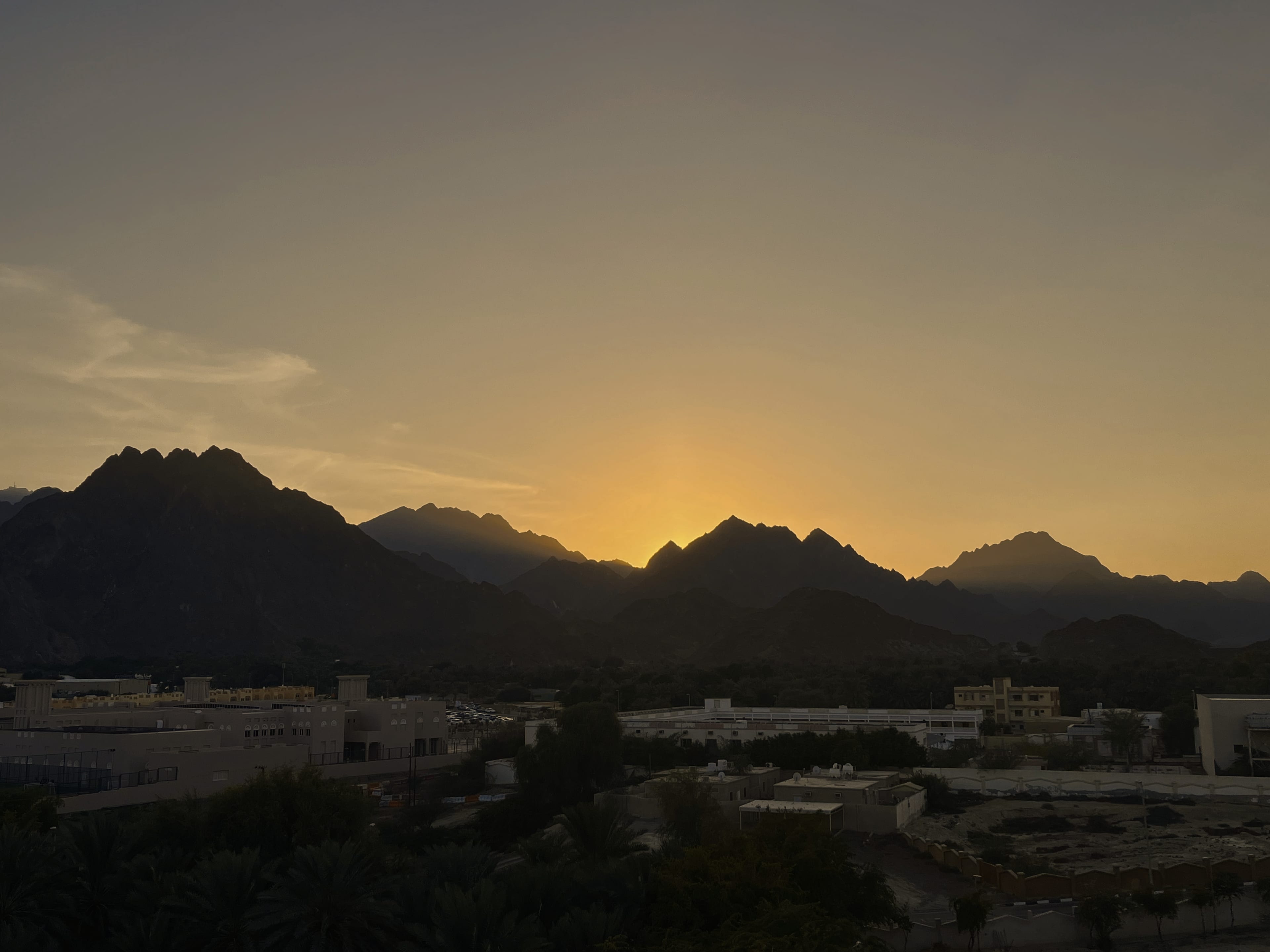 The Hajar mountains around Hatta silhouetted against a golden sunset